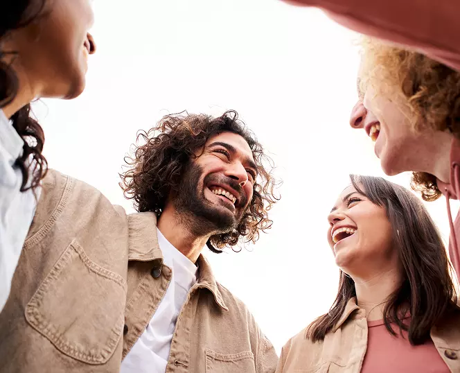there are four people standing together and laughing together