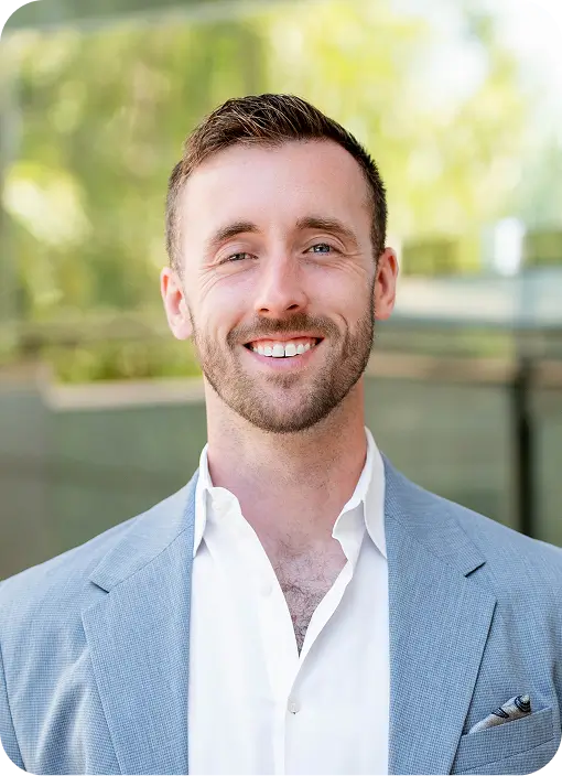 a close up of a man in a suit smiling at the camera