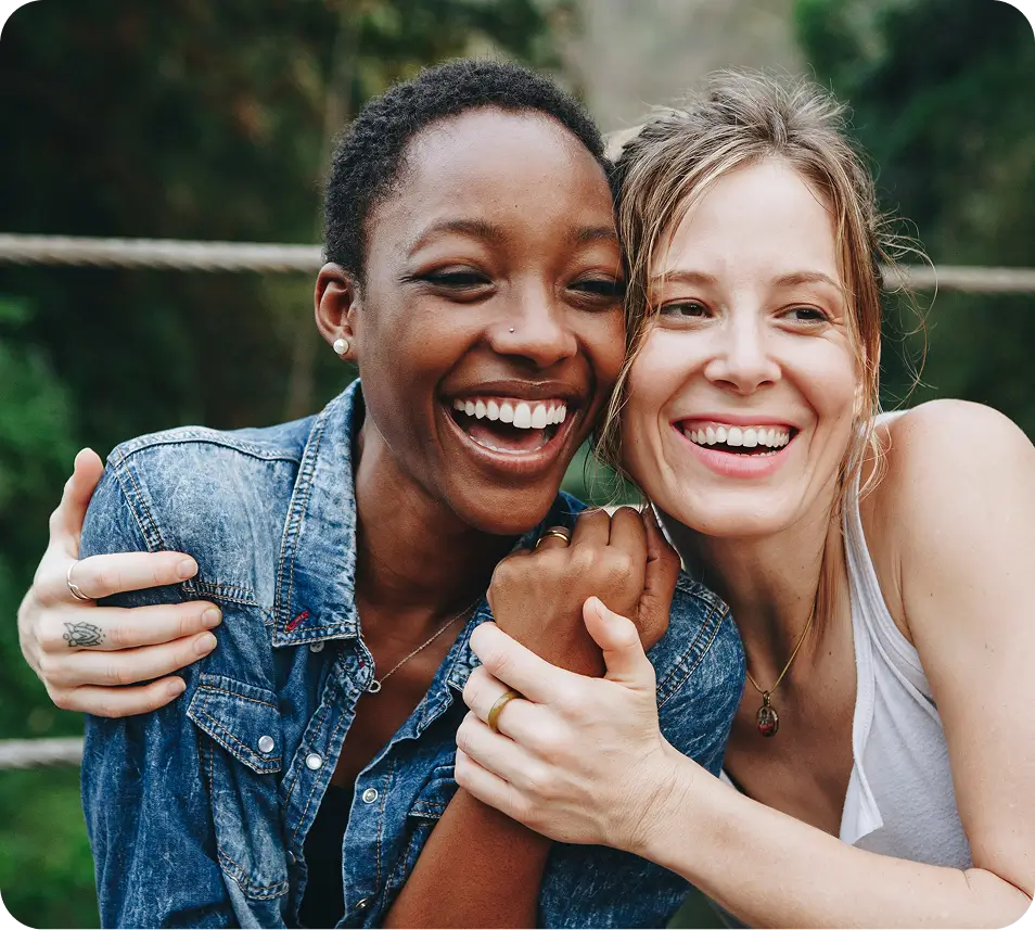 there are two women that are smiling and hugging each other
