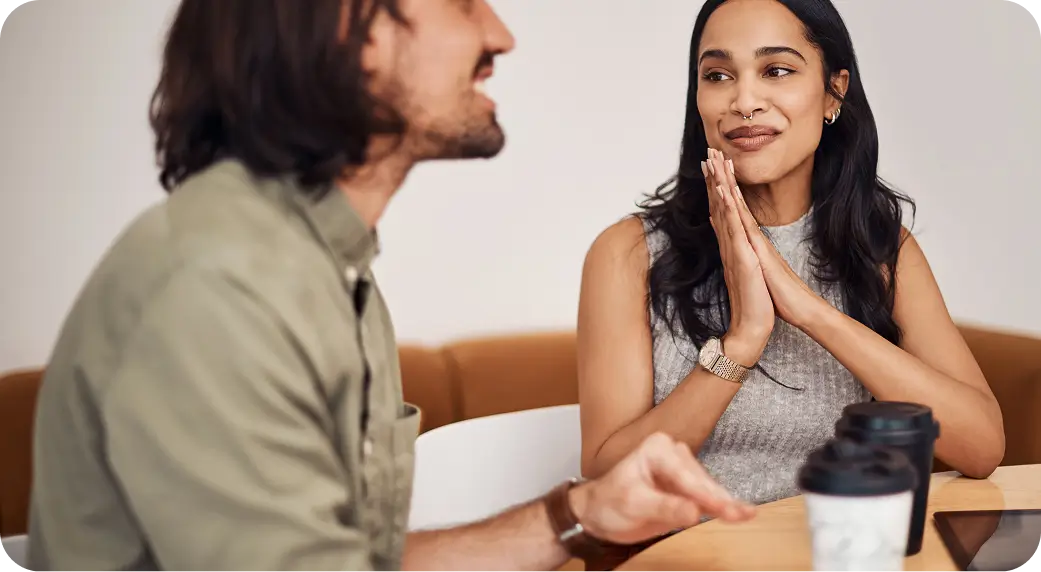 arafed woman sitting at a table with a man who is talking to her