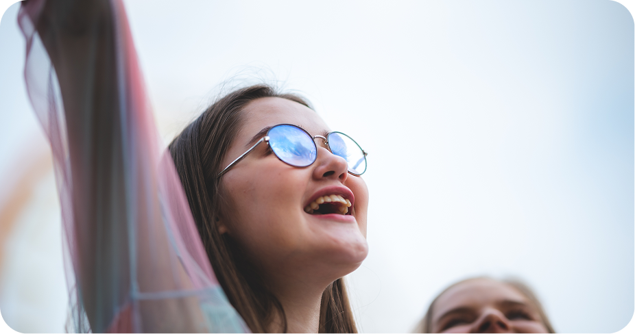 there is a woman with glasses smiling and looking up