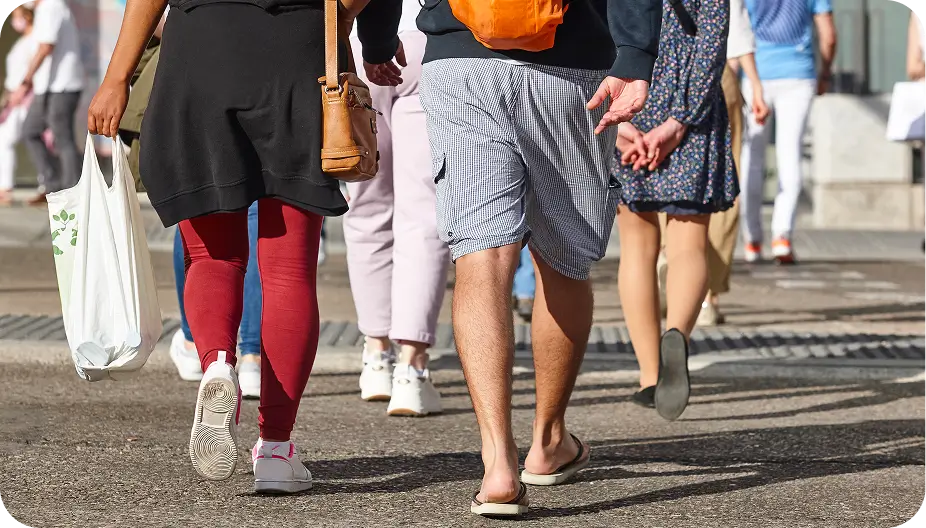 people walking down the street with bags and bags on their backs