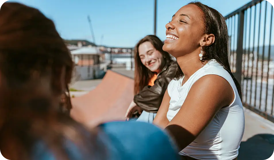 there are three women sitting on a bench and one is smiling