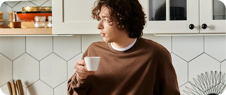 there is a woman standing in a kitchen holding a cup