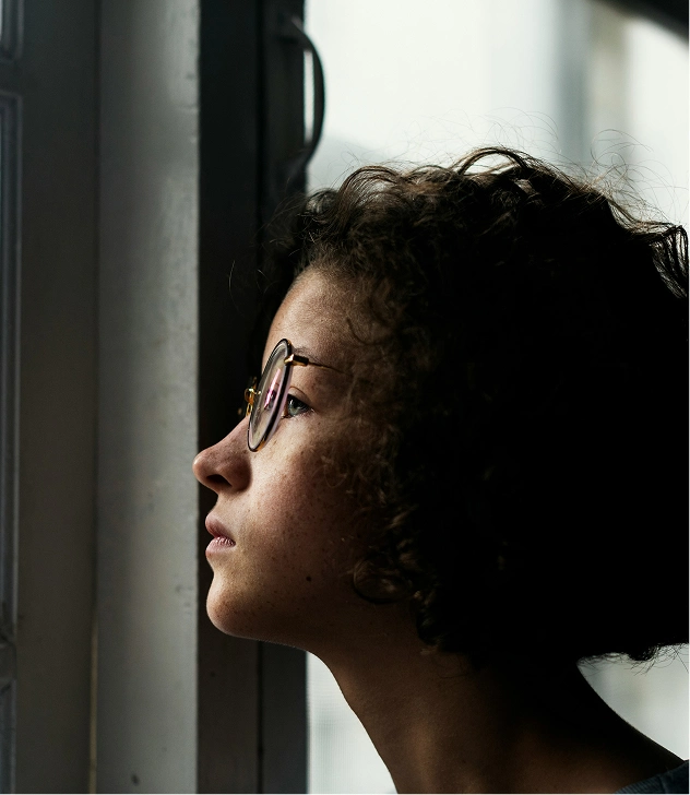 there is a woman looking out a window with a pair of glasses on