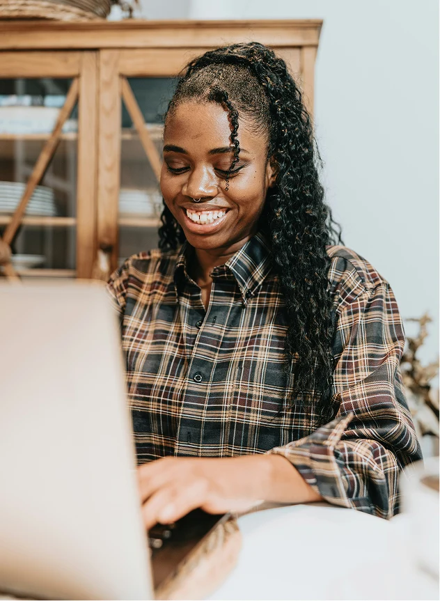 smiling woman using a laptop computer at home