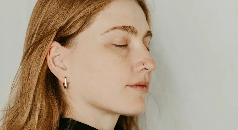 a woman with her eyes closed wearing a black turtle neck