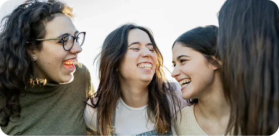 three women are laughing and laughing while standing together