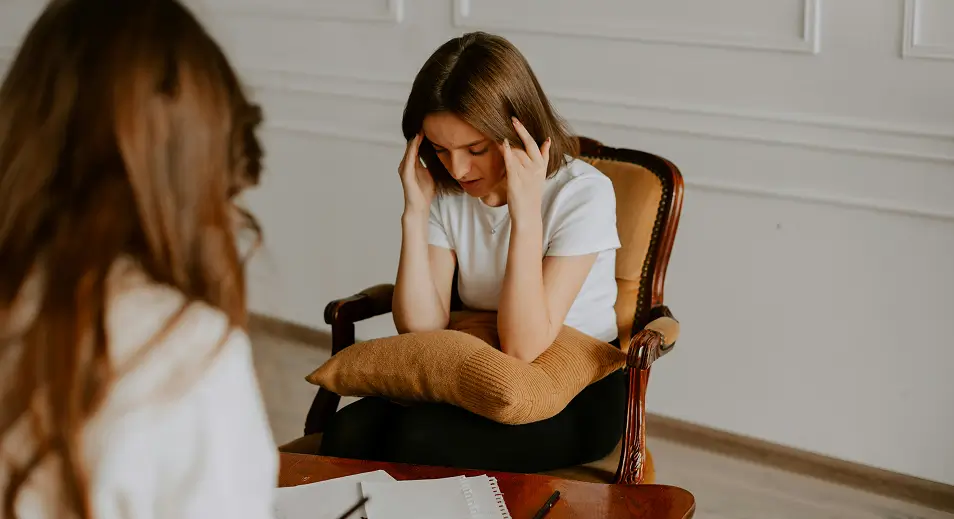 a woman sitting in a chair talking on a cell phone