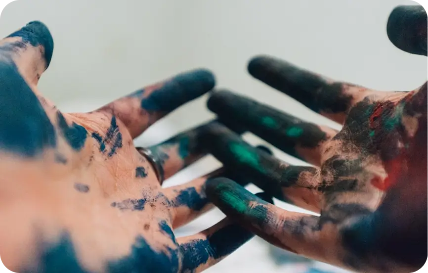 someone is holding their hands with paint all over them
