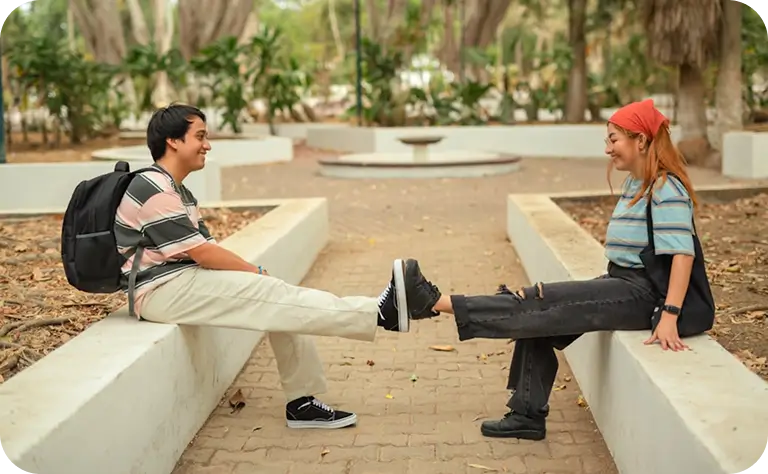 there is a man and woman sitting on a bench talking