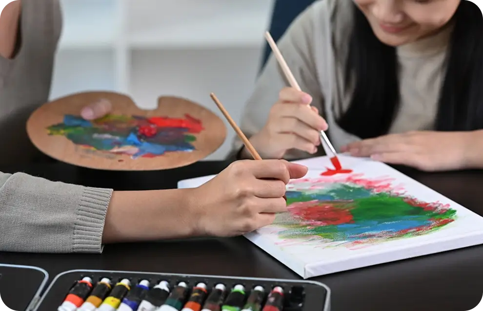 there is a woman painting with a brush and palette on a table
