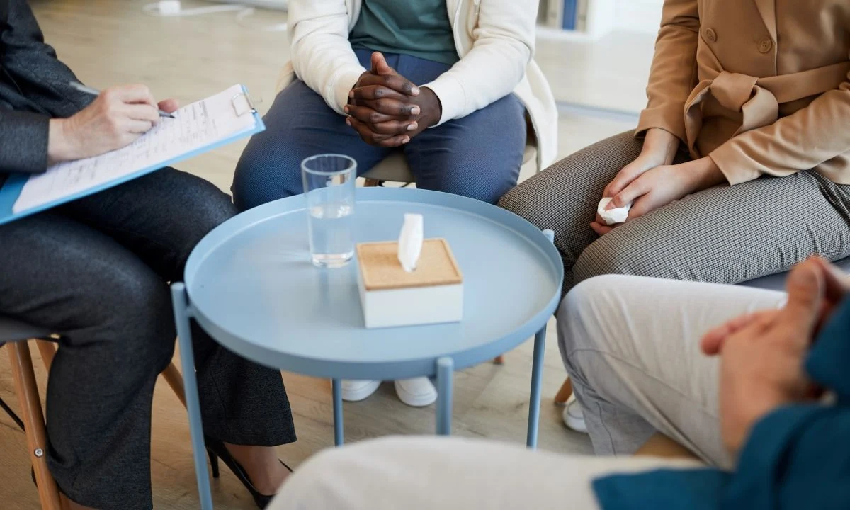 several people sitting around a table with papers and a glass of water