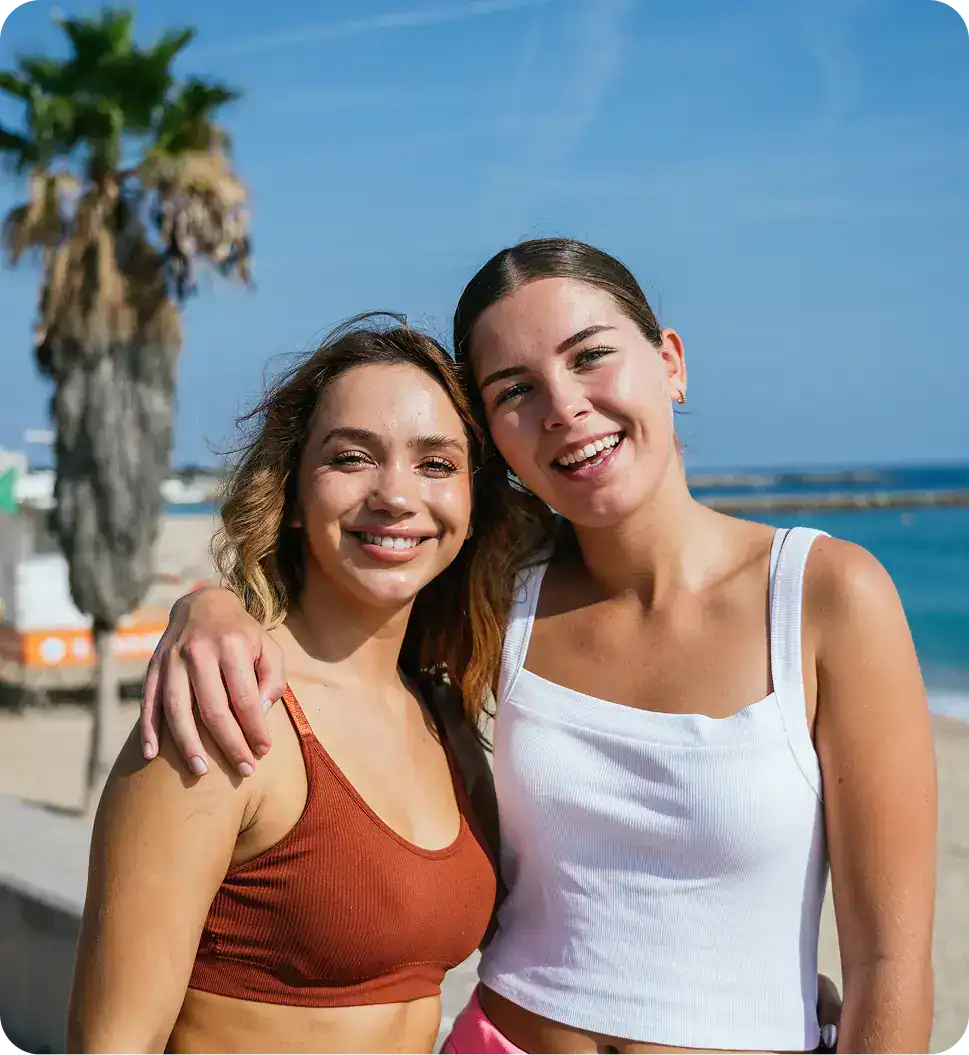 Two women embracing and smiling outdoors while celebrating recovery after marijuana rehab in Easton, MA at Rebuilding Recovery Center.