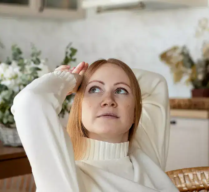 Woman holding her head while coping with emotional distress before seeking alcohol rehab in Massachusetts at Rebuilding Recovery Center.
