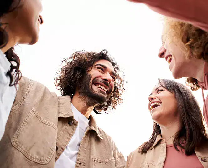 there are four people standing together and laughing together