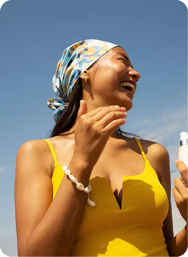 smiling woman in yellow dress holding a cell phone and smiling