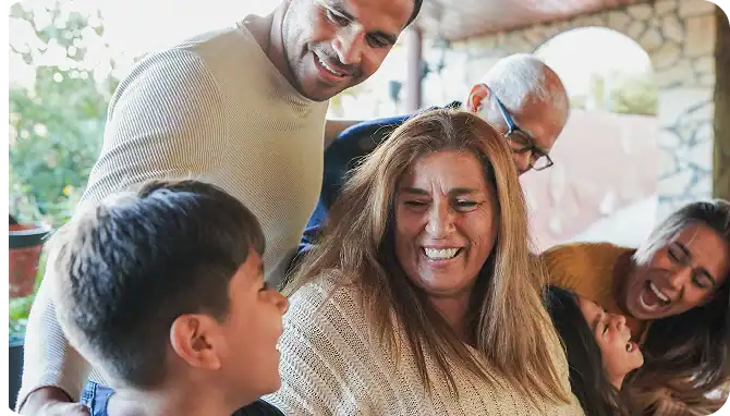 Happy family smiling together after making progress through gambling addiction treatment in MA at Rebuilding Recovery Center.