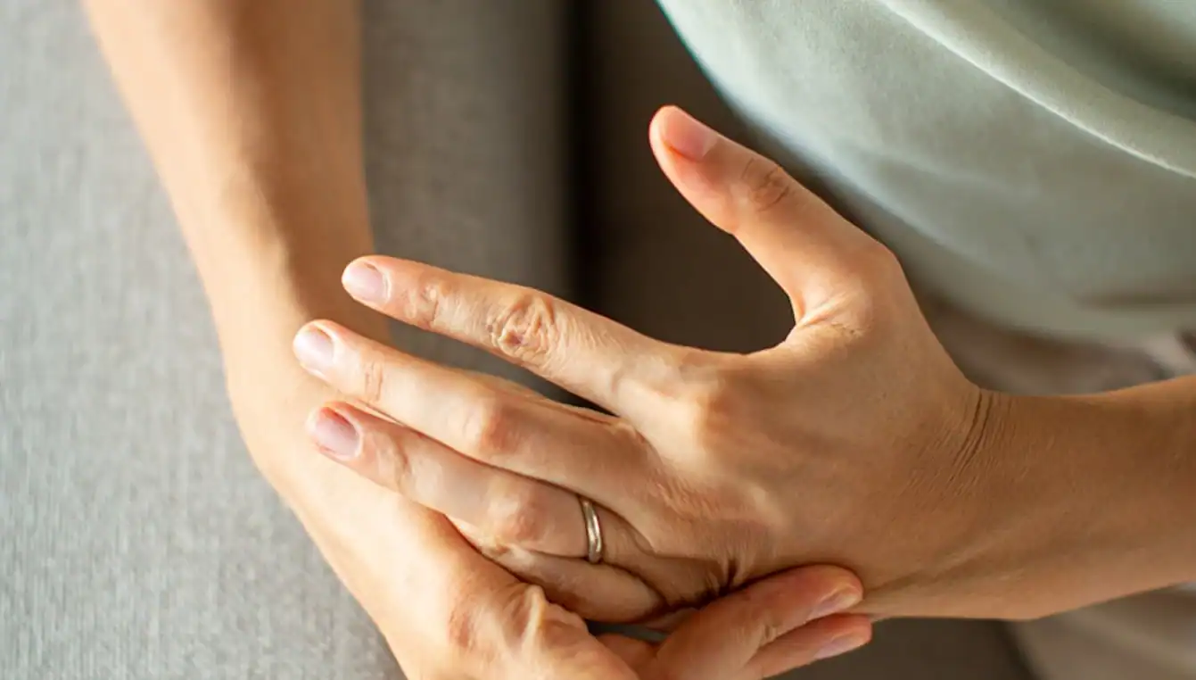 Person holding their own hand while thinking about how to Referrals for Detox in Massachusetts