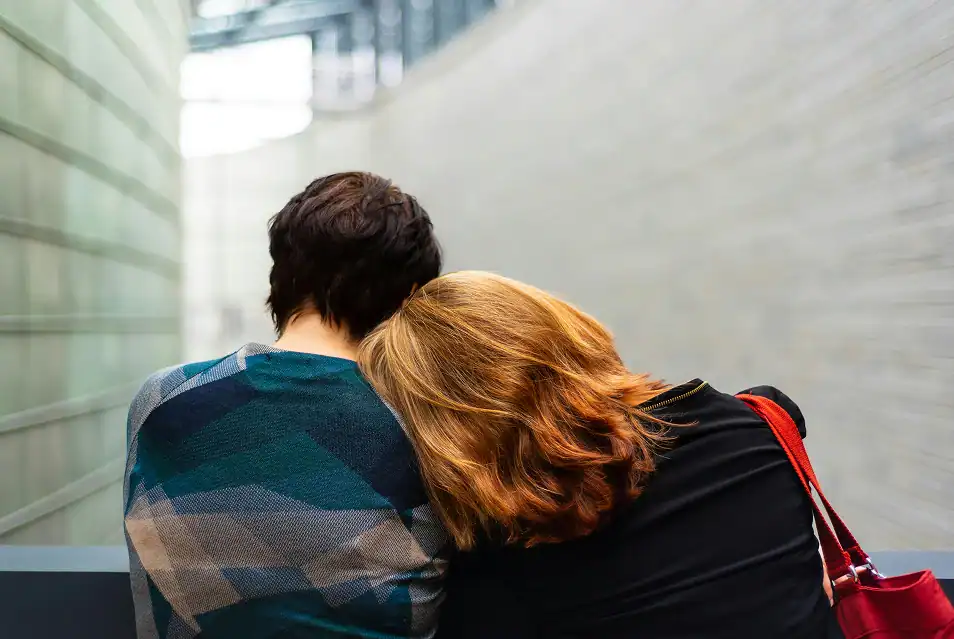 Two people sitting together on a bench, offering comfort and support during meth addiction treatment in MA at Rebuilding Recovery Center.