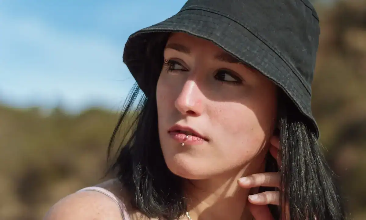 Young woman with black hair and bucket hat outdoors in Easton, MA.