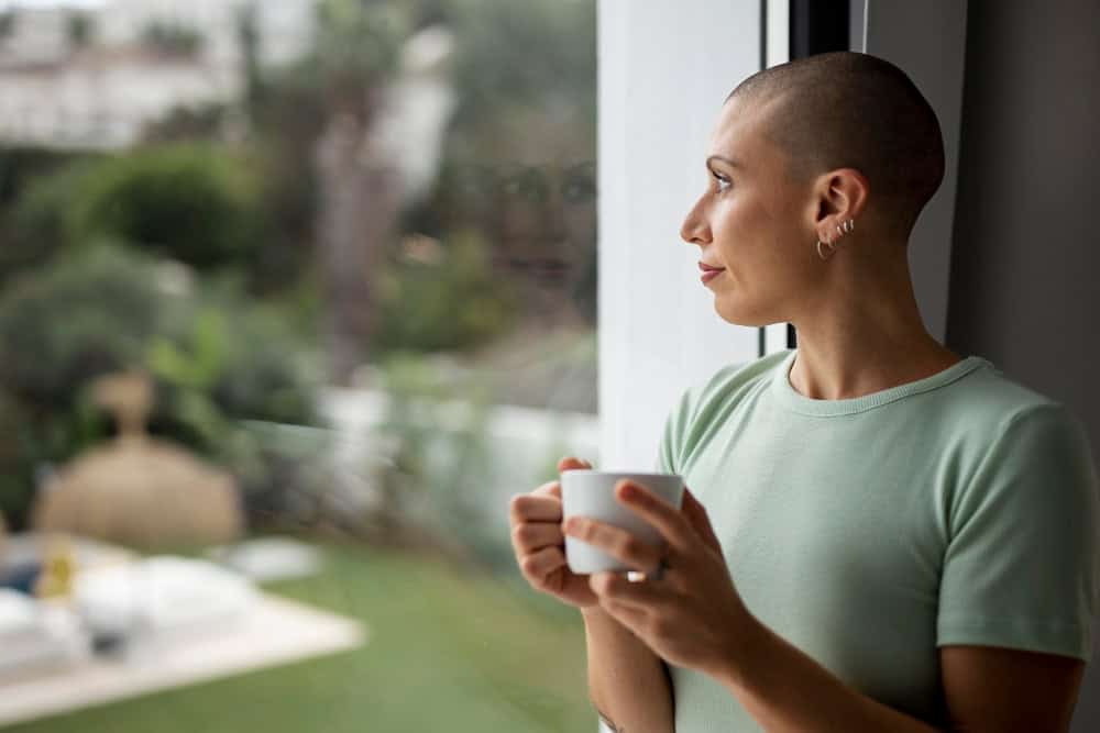 Woman drinking coffee and reflecting at home during relapse prevention planning.