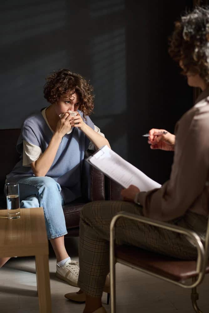Young woman wiping tears during individual therapy in Easton, MA.