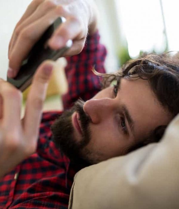 Man using a smartphone while engaging in online gambling in Easton, MA.
