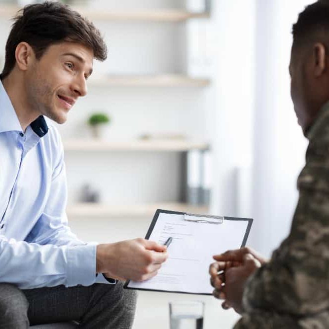 Psychologist providing guidance to an African American military service member during veteran substance abuse treatment in Easton, MA.