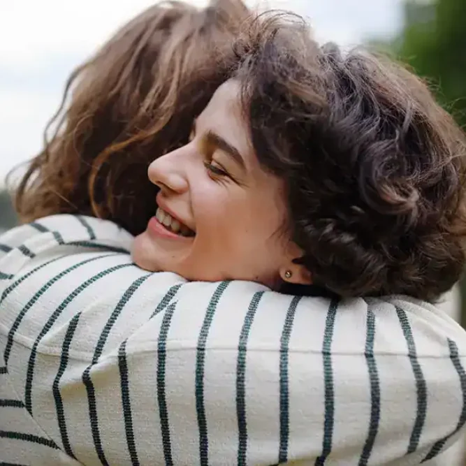 Two women embrace after a section of PHP in Massachusetts.