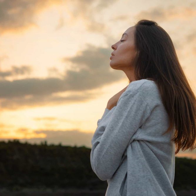 Woman spending time outside while navigating PTSD symptoms and emotional challenges.