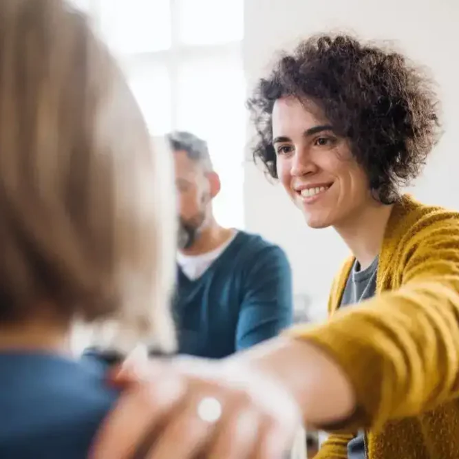 Woman comforting another participant during a group therapy session for Xanax addiction treatment in Easton, MA at Rebuilding Recovery Center.